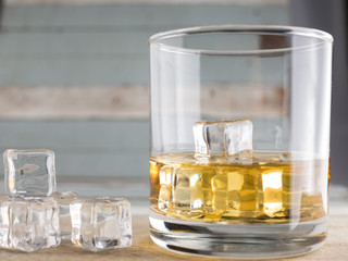 whiskey glasses with ice cubes isolated on old wood