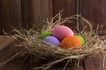 Fototapeta na wymiar Easter eggs in nest on old wooden background