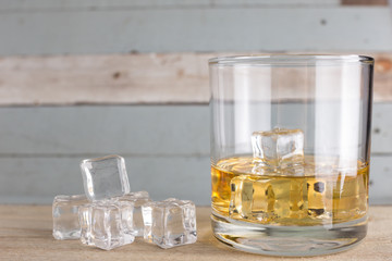 whiskey glasses with ice cubes isolated on old wood