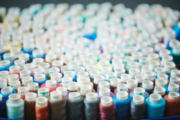 Closeup shot of colorful sewing rolls on table in atelier