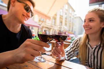 Young couple with glasses of red wine in a restaurant with city view