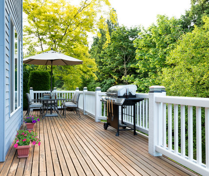Home deck and patio with outdoor furniture and BBQ cooker with bottled beer