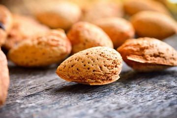 Almonds on textured wooden background