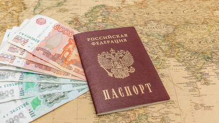 Russian passport with money within on the world map