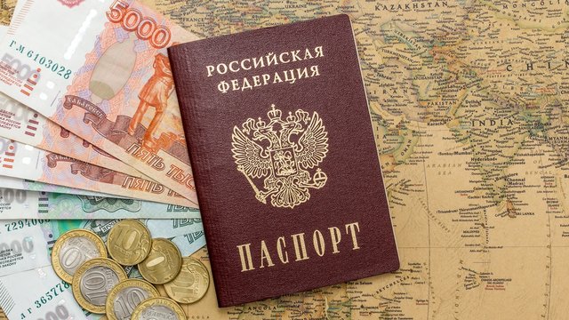 Russian passport with money within on the world map