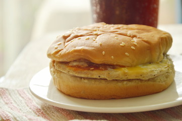 hamburger and cola with ice in plastic cup