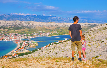 Father and daughter watching the town of Pag, Croatia