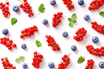 Flat lay of blueberries and currants pattern. Berry fruit with green leaves repetition. Top view