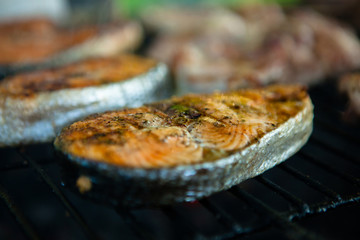 3 pieces of grilled fish with spices on fire, close-up, golden crust