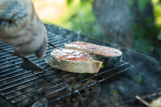 two pieces during cooking on the barbecue grill, salmon on the coals, a dish from the chef