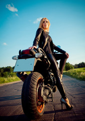 Fototapeta na wymiar Biker girl sits on a motorcycle