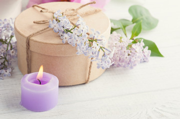 Lit purple candle and lilac flowers