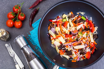 Mix vegetables with shiitake in frying pan. View from above