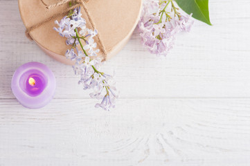 Obraz na płótnie Canvas Lit purple candle and lilac flowers