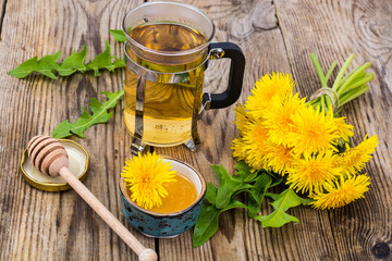 Herbal tea and honey from dandelions on wooden background.