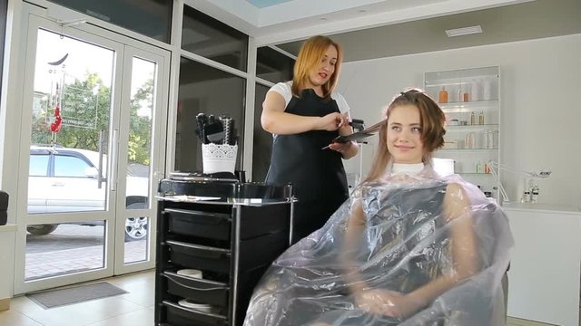 Professional hairdresser, stylist coloring teen girl hair