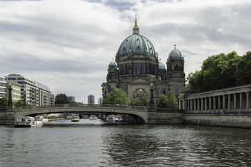 Fototapeta na wymiar Side view of the Berlin Cathedral next to the river Spree and the Friedichsbrücke, Germany