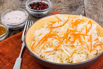 Salted cabbage on plate on the background of wooden table