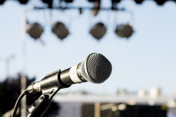 close up of a microphone on stage with lights in the background  