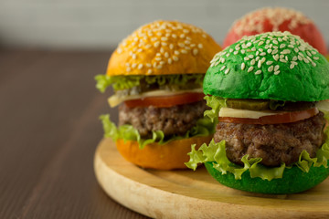 Green, yellow and red burger on wooden table