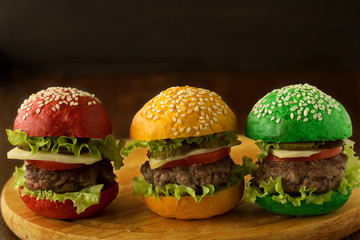 Green, yellow and red burger on wooden table