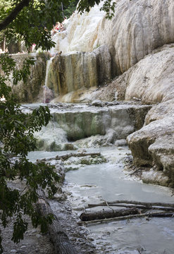 Mineral rock of Bagni San Filippo in Italy, with its hot spring stream, surrounded by nature