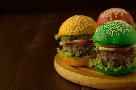 Green, yellow and red burger on wooden table
