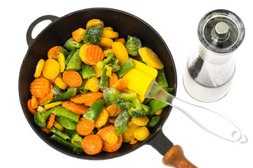 Frozen vegetables in cast-iron frying pan