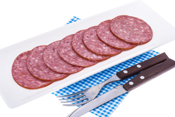 Slices of salami on white plate