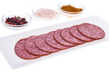 Slices of salami on white plate