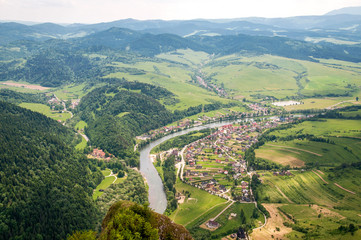 Widok na rzekę, zabudowania i zielone wzgórza. © sly10000