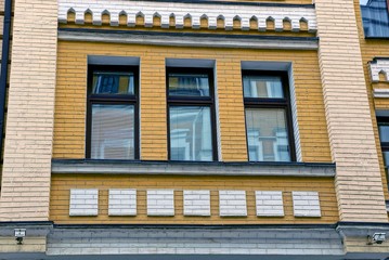 Obraz premium Три окна на современном кирпичном жилом здании