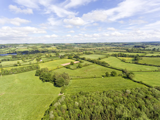 Aerial view of rural english countryside of green farm fields, wildflower meadows, hedgerow, woods, on a summer day . - 158773416