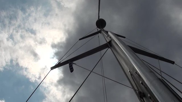 Upview of mast against the clouded sky