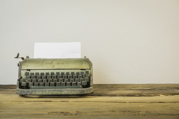 Old typewriter with blank paper,Old retro typewriter on table on white background,Retro typewriter placed on wooden planks,Vintage typewriter and a blank sheet of paper,vintage tone,selective focus.