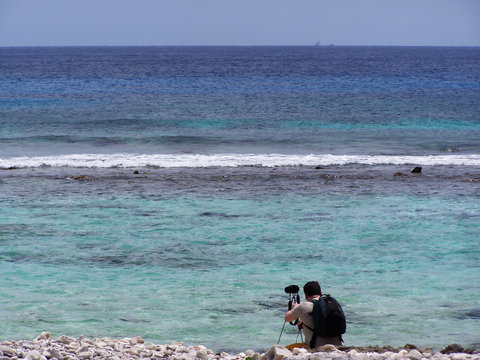 A photographer taking a picture of the beautiful ocean
