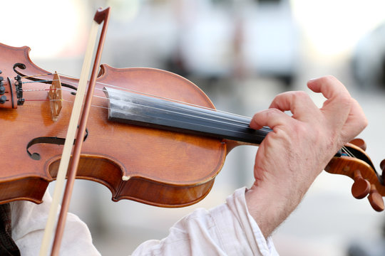 hand violinist violin while playing on it outdoors