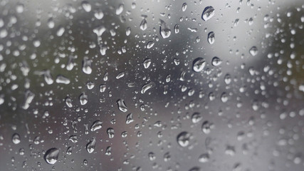 Naklejka na ściany i meble Rain falling on glass during rain storm