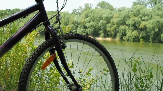 Bicycle on vacation. A mountain bike close up near a river.
