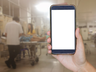 closeup of man with smart phone, Man hand holding mobile smart phone , tablet,cellphone over Blurred of Patient lying on a hospital bed waiting for the emergency treatment of a doctor background.
