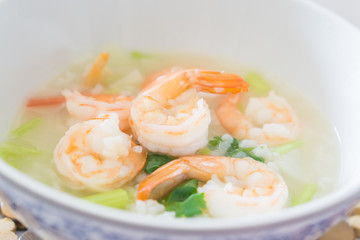 Shrimp porridge,Rice porridge with shrimp in white bowl,Porridge rice with shrimps and fried garlic. white colors fabric background,selective focus