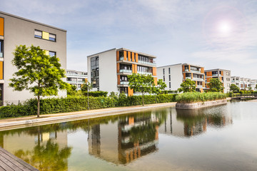 Neubausiedlung Panorama am Wasser mit Gegenlicht - obrazy, fototapety, plakaty