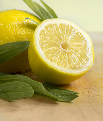 Some yellow, ripe and fresh lemons are on the wood table.