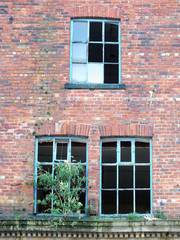 broken windows in an abandoned derelict brick building