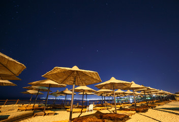 sunshade beach umbrellas against night sky in Egypt