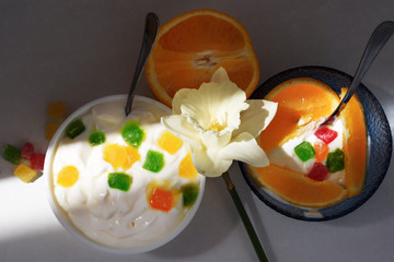 Yogurt with slices of fruit, candied fruits and white narcissus flower