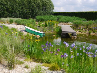łódka,mostek nad wodą wśród kwiatów