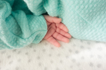 Fototapeta na wymiar Newborn hand placed on a soft blanket, background