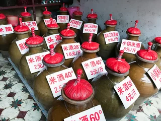Selbstklebende Fototapeten jugs with local alcohol drinks on city market © vvoe