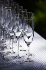 Empty glasses arranged on a table in the restaurant, cafe, or bar. Preparation for the birthday, wedding, or any celebration day.
